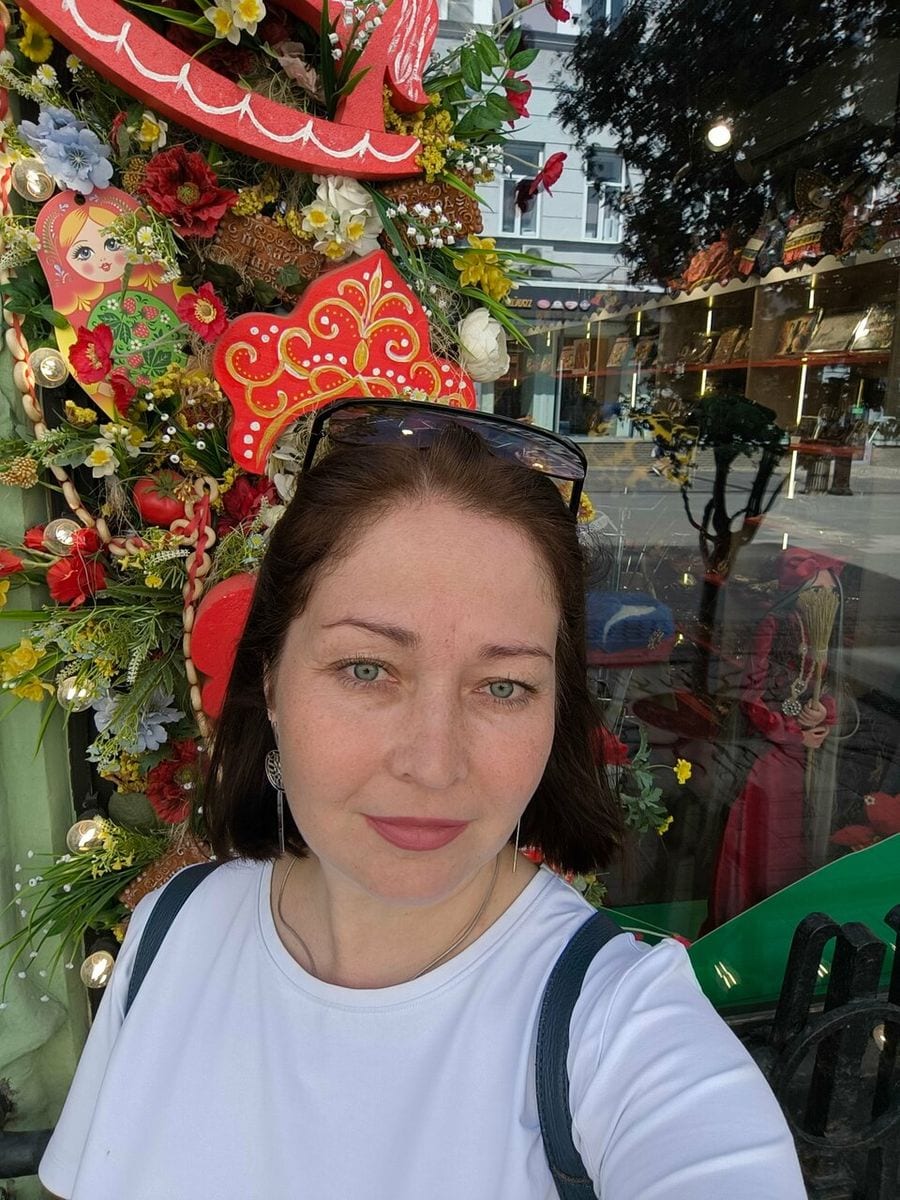 Витрина магазина снаружи, украшенная цветами и деревянным конём